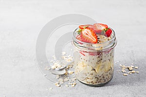 Overnight Oats with Fresh Strawberry, Banana and Chia Seeds in Jars on Light Grey Background, Healthy Snack or Breakfast