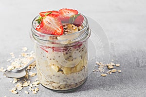 Overnight Oats with Fresh Strawberry, Banana and Chia Seeds in Jars on Light Grey Background, Healthy Snack or Breakfast