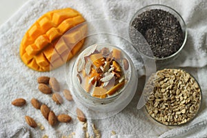 Overnight oats with mango and almonds. Made by soaking rolled oats and chia seeds in milk served with chopped mangoes, almonds and