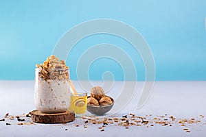 Overnight oats with walnuts, accompanied with honey and whole walnuts