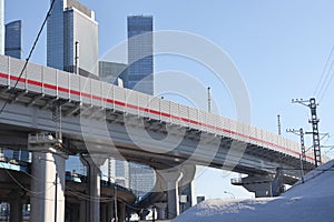Overpasses on the background of skyscrapers. Blue sky and bright sun. Transport interchanges and urbanism