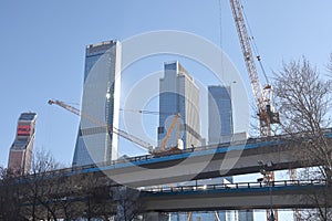 Overpasses on the background of skyscrapers. Blue sky and bright sun. Transport interchanges and urbanism