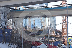 Overpasses on the background of skyscrapers. Blue sky and bright sun. Transport interchanges and urbanism