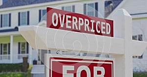 Overpriced for sale real estate sign with a new home in the background.