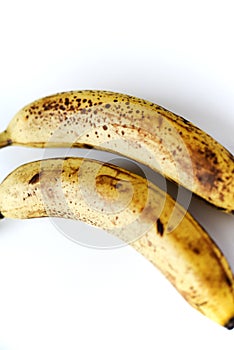 Overripe bananas on a white background. Ripe yellow fruit
