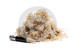 Oversharpened pencil in front of the heap of shavings. Concept of the fruitless design or art work