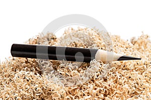 Oversharpened pencil in front of the heap of shavings. Concept of the fruitless design or art work