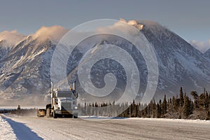 Oversize load truck in the road with forests and snowy mountains in Whitehorse, Yukon, Canada