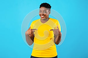 Oversized African Lady Pointing Fingers At Herself Over Blue Background