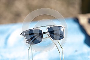 Oversized sunglasses design with big black flat lenses closeup shoot outside in a summer day . Selective focus