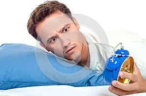 Overslept man looking at blue alarm clock horrified photo