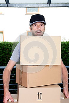 Overstrained postman with parcels photo