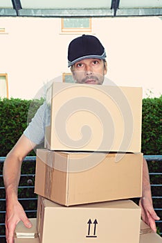 Overstrained postman with parcels photo