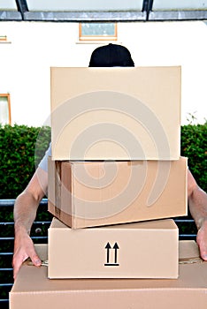 Overstrained postman with parcels photo