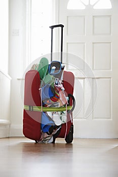 Overstuffed suitcase in hallway