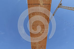 Overthrow with red construction blocks under blue sky with crane