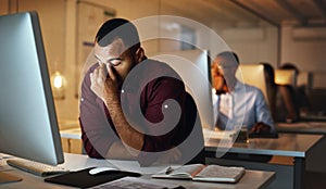 Overtime is starting to kill me now. a young businessman looking stressed out while working late in an office.