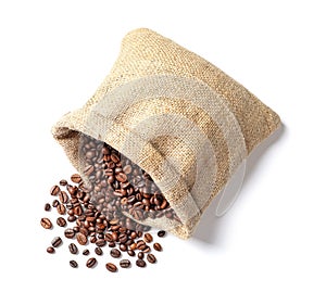 Overturned bag with roasted coffee beans on white background