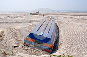 An overturned blue coloured boat in a beach in Konkan photo