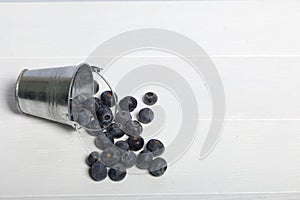 Overturned decorative bucket. Scattered large blueberries. International day without diets. On a white background. Close-up