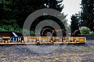 Overturned derailed railroad car lying next to the tracks photo