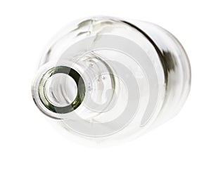 Overturned empty clear brandy bottle isolated