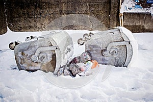 Overturned garbage containers during strong and snowy winter