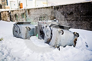 Overturned garbage containers during strong and snowy winter