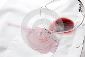 Overturned glass and spilled exquisite red wine on shirt. Space for text