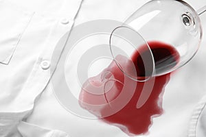 Overturned glass and spilled exquisite red wine on shirt. Space for text