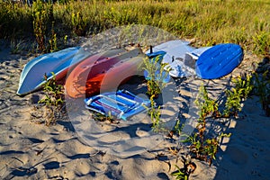 Overturned multi-colored Kayaks Cover the Sand