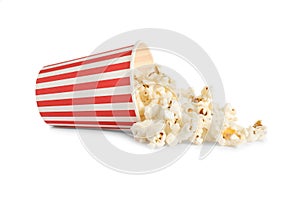 Overturned paper cup with delicious popcorn isolated