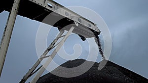 An overview of a coal falling from the belt conveyor at the coal mine