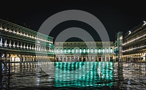 Overview of piazza San Marco in Venice, Italy during a rainy night time, with reflections on the floor. Beautiful postcard from