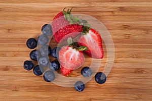 Overview red sweet strawberries blueberries on a bamboo cutting board