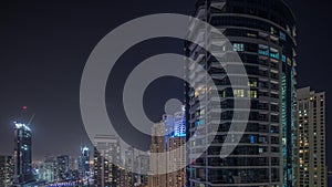 Overview to JBR and Dubai Marina skyline with modern high rise skyscrapers waterfront living apartments aerial night