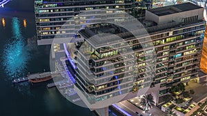 Overview to JBR and Dubai Marina skyline with modern high rise skyscrapers waterfront living apartments aerial night