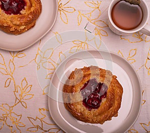 Overview of two Cherry Danish\'s with a cup of tea