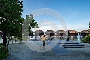 Overwater beach bungalow huts and villas at a resort in the Maldives