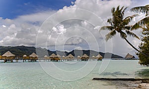 Overwater bungalows stretching and a wooden bridge out across the lagoon in Bora Bora island