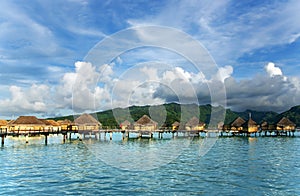 Overwater bungalows stretching and a wooden bridge out across the lagoon in Bora Bora island