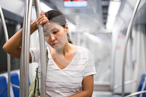 Overweary woman waiting for her stop in metropolitan train