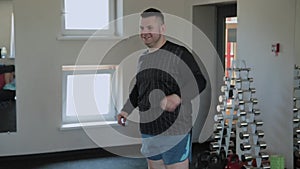 Overweight adult man warming up in the gym.