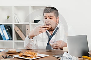 overweight businessman eating donuts, hamburger and french fries