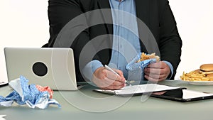 Overweight businessman eating fast food at office.