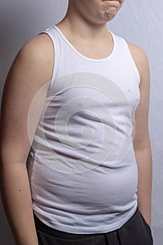 Overweight caucasian teenage boy in a sleeveless top