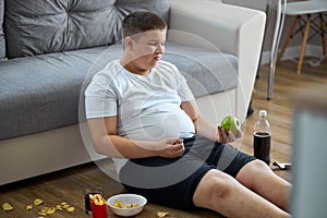 An overweight child boy enjoy leading unhealthy passive lifestyle