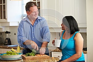 Overweight Couple On Diet Preparing Vegetables In Kitchen