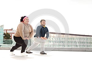 Overweight couple doing sport exercises together