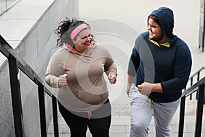 Overweight couple running up stairs together photo